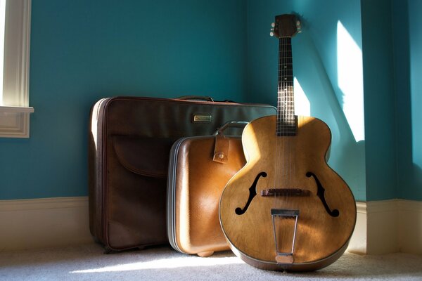 Guitar and suitcases flooded with sunlight