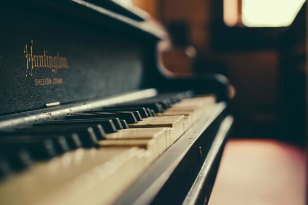 An old piano stands next to the window