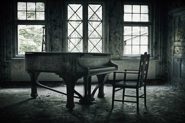 Opuszczony pokój z fortepianem i krzesłem