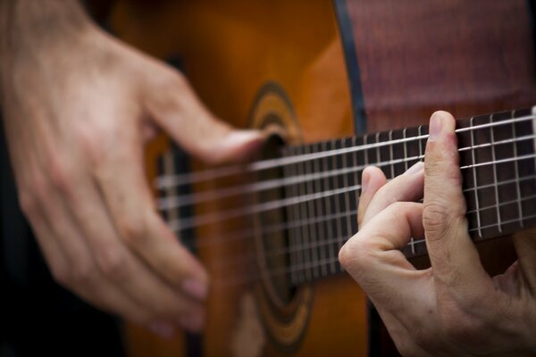 Mani che suonano la chitarra