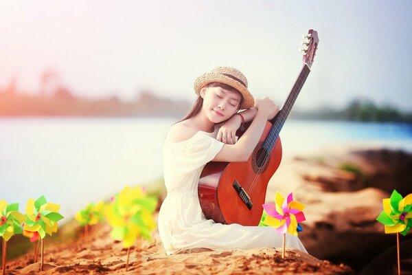 A girl with a guitar on the shore