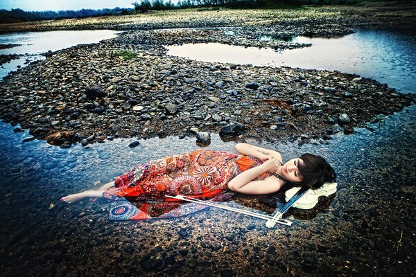 A girl with a violin in nature