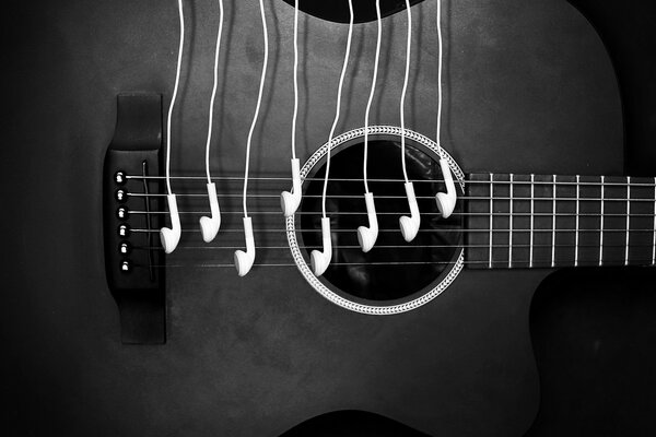 Czarna gitara z białymi słuchawkami