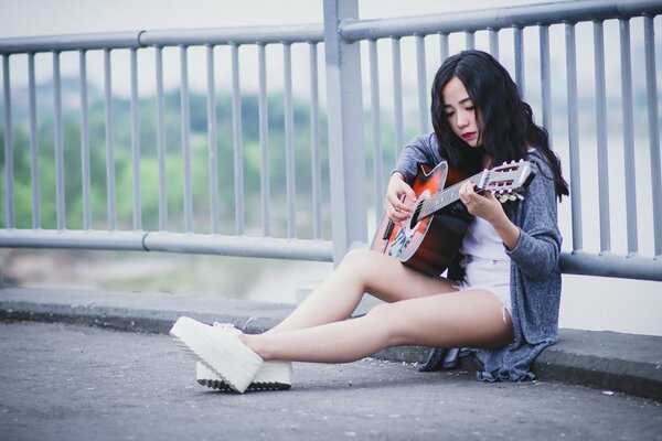 Beautiful girl playing music on guitar