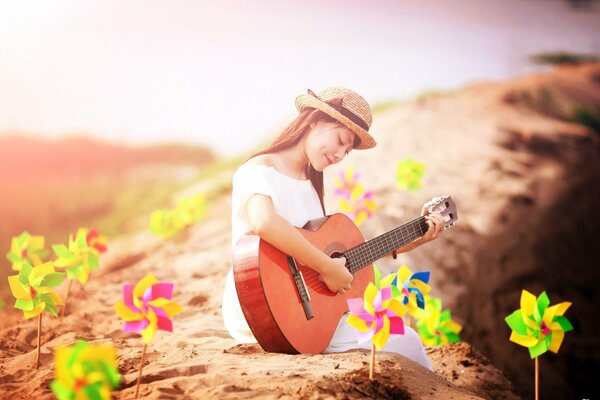 A girl with a guitar on the seashore