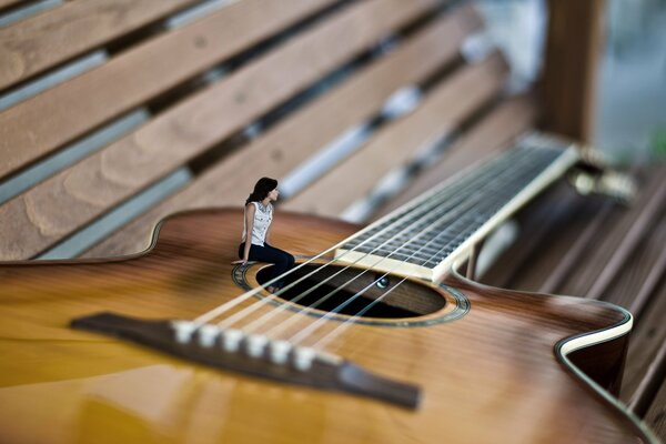 The girl plays beautiful music on the guitar