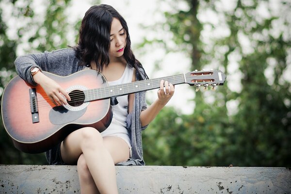 Schönes Mädchen spielt Musik auf der Gitarre