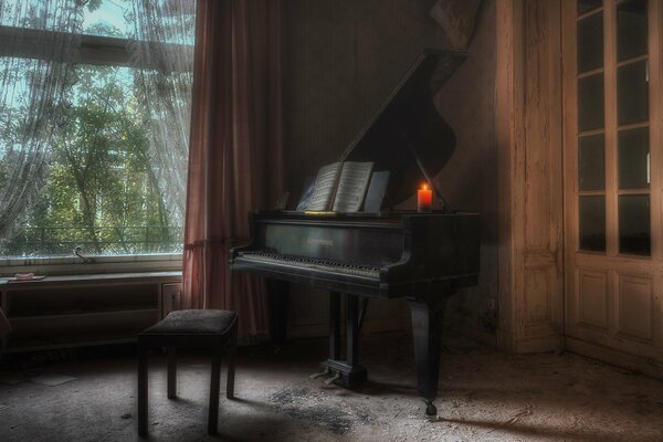 Photo of a piano with a candle on it