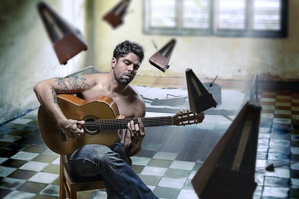 A man plays guitar indoors