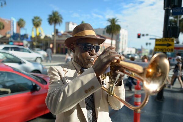 A jazzman in a hat plays the trumpet