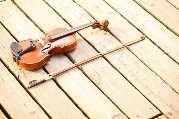 The violin and bow are lying on the wooden floor