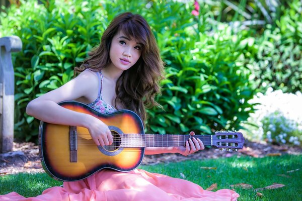 Brunette plays guitar in the garden