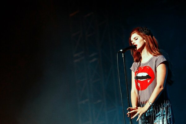 Red-haired singer in a bright T-shirt on stage