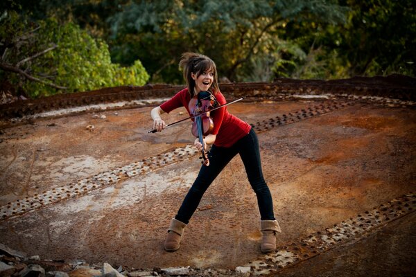 Beautiful violinist on the roof of the house