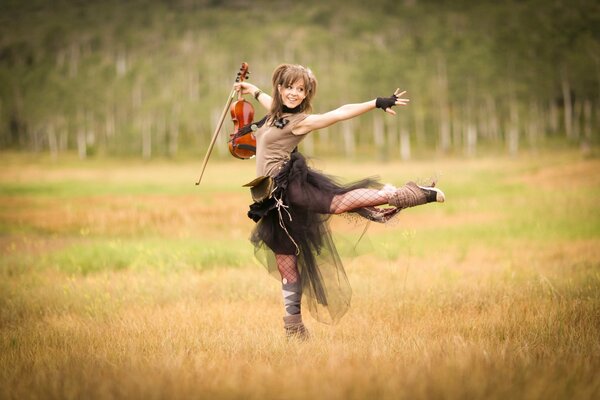 A girl in a field with a violin in motion