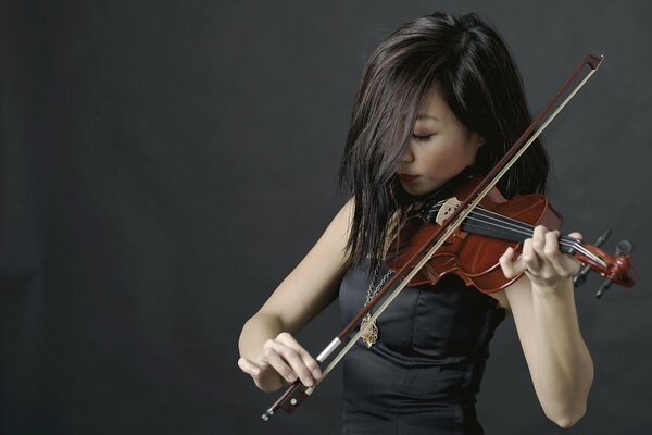 A girl plays a melody on a violin