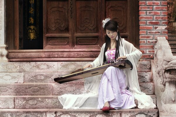 Ragazza asiatica gioca su Guzheng