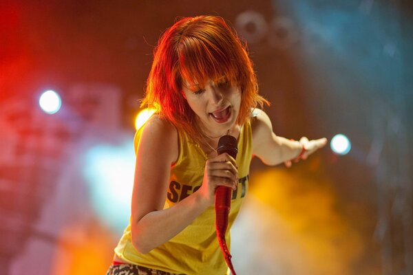 A red-haired singer sings on stage