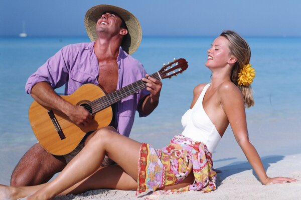 Guy joue de la guitare pour un amant au bord de la mer