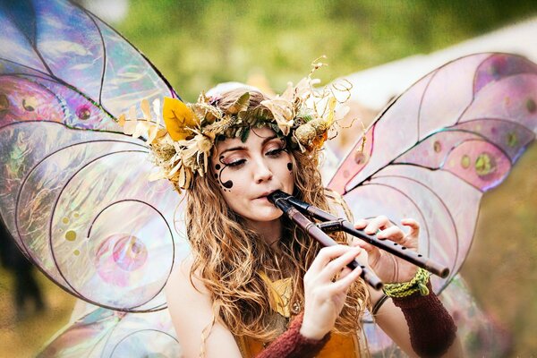 Chica en traje de mariposa con flauta