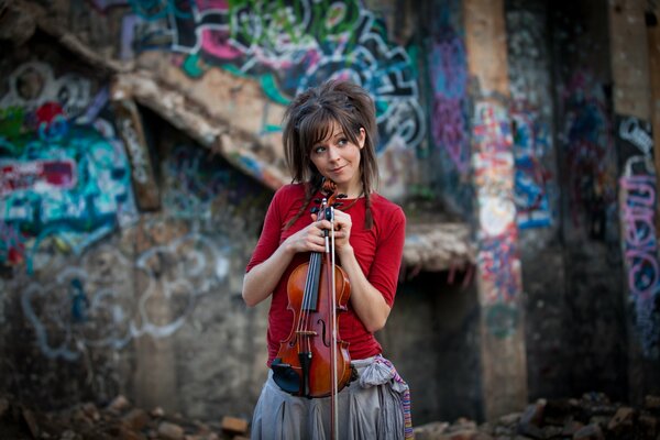 Lindsey Stirling e violino vicino al muro dipinto