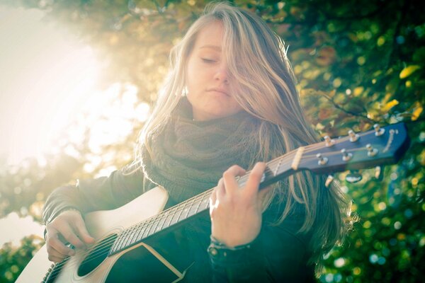 Fille aux cheveux clairs avec guitare