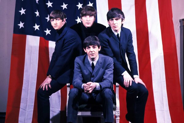 Die Beatles vor dem Hintergrund der amerikanischen Flagge sitzt McCartney vorne
