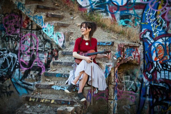 Violinista alegre en el fondo de un edificio abandonado