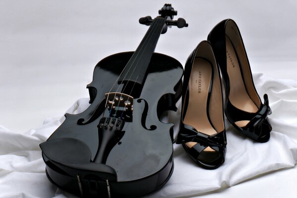 Schwarze Geige und schwarze Schuhe mit weißem Stoff