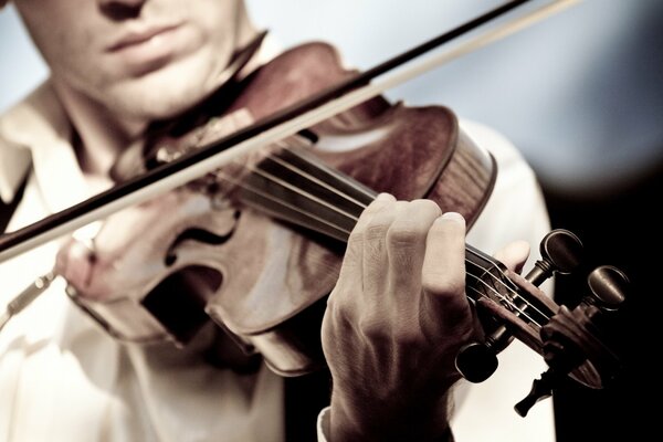 Uomo che suona il violino su sfondo scuro