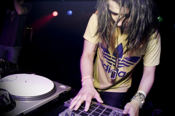DJ au travail dans un t-shirt élégant joue de la musique dubstep