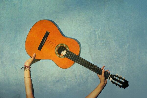 La chitarra è tenuta su uno sfondo blu