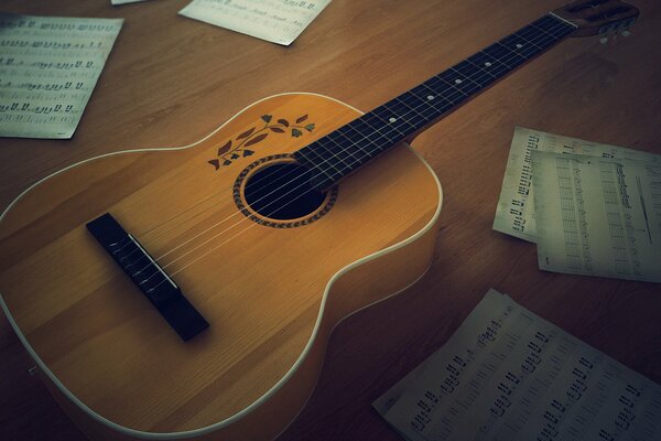 Guitare sur la table parmi les notes