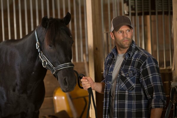 Jason Stetham con un cavallo nella stalla