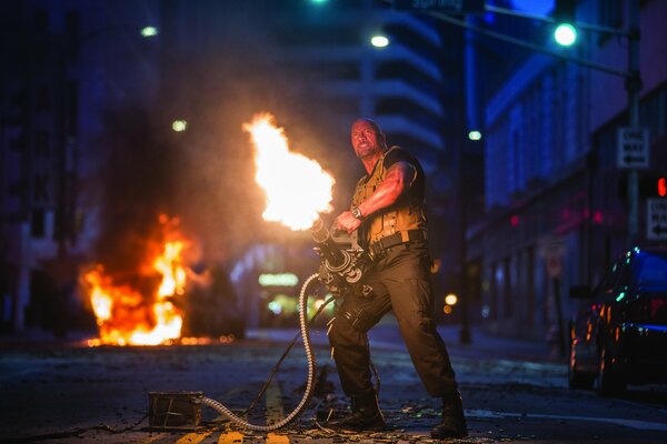 Dwayne Johnson dans la rue avec une arme à feu crachant ogre