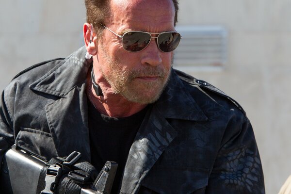 Arnold envejecido con armas y gafas