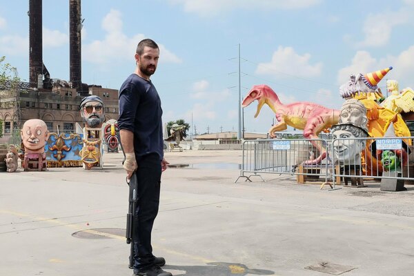 Anthony Starr mit Waffen auf einer Kinderattraktion