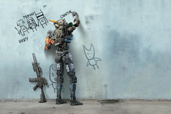 The robot writes a word on the wall, and there is a weapon next to it