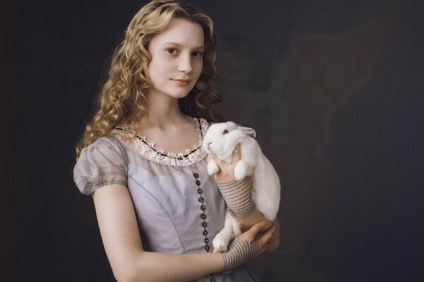Alice en un vestido con un conejo
