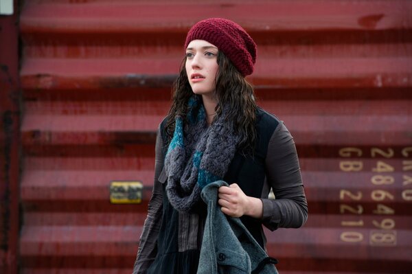 The girl is standing in a burgundy beret