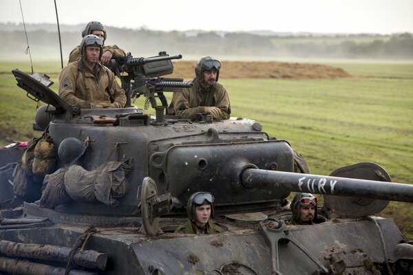 Five soldiers are riding on a tank