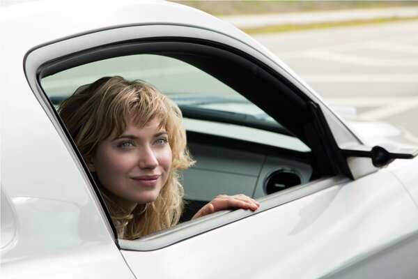 Sonrisa astuta de una chica en la ventana del coche