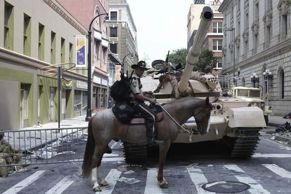 Policía a caballo frente a un tanque