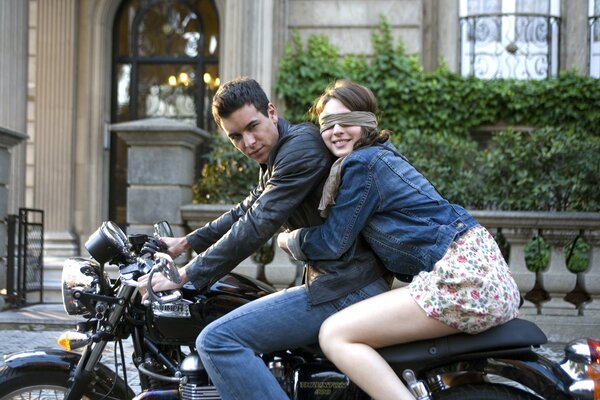 Chico con suerte chica con los ojos cerrados en una motocicleta