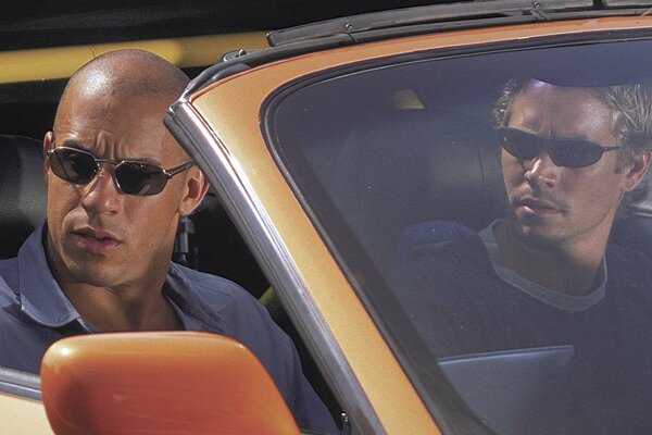 Deux hommes dans une voiture orange
