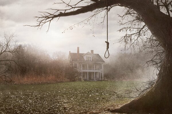 A gloomy mansion and a tree with a rope