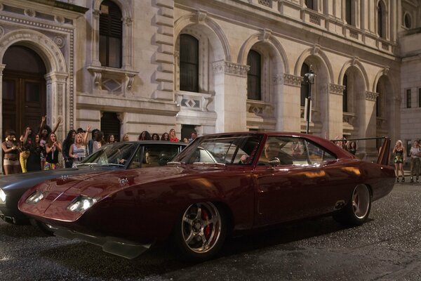 Dos coches de carreras en el fondo de un edificio alto