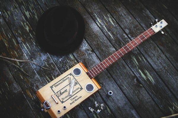 Gitarre und Hut auf einem alten Holzboden