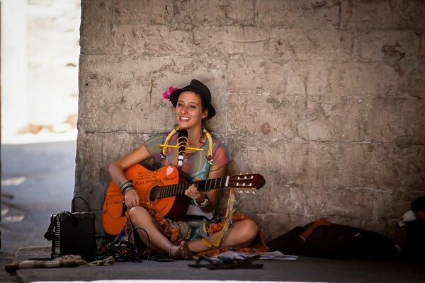 La chica con la guitarra en la pared