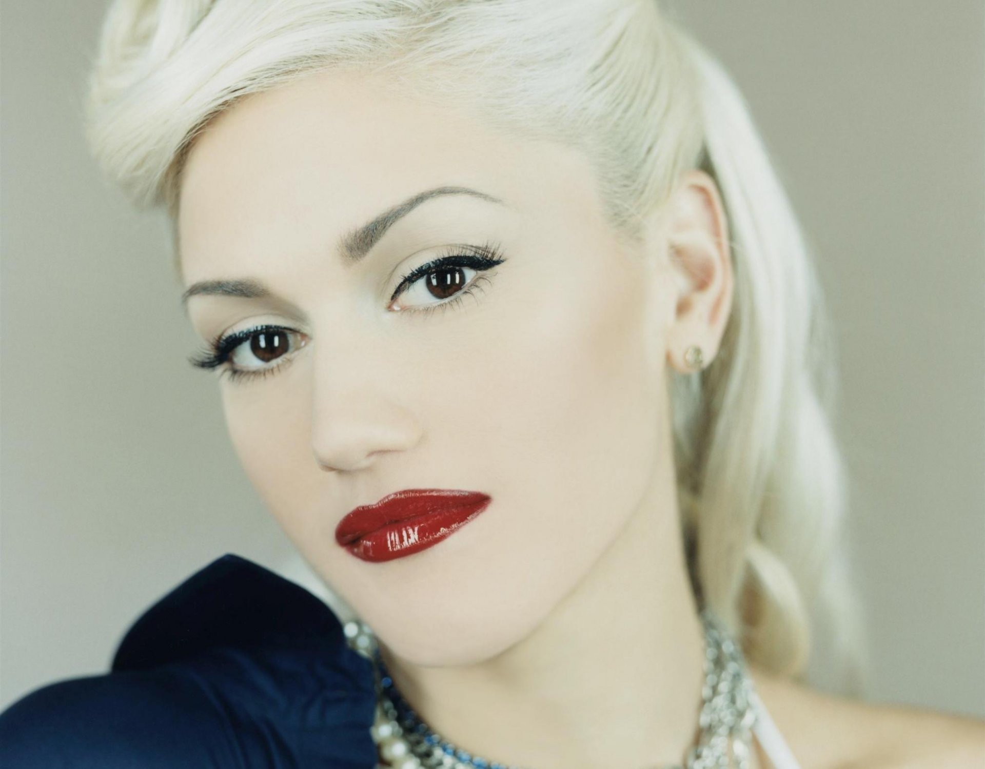 gwen stefani cara mirada labios rojos maquillaje rubia cabello peinado joyas